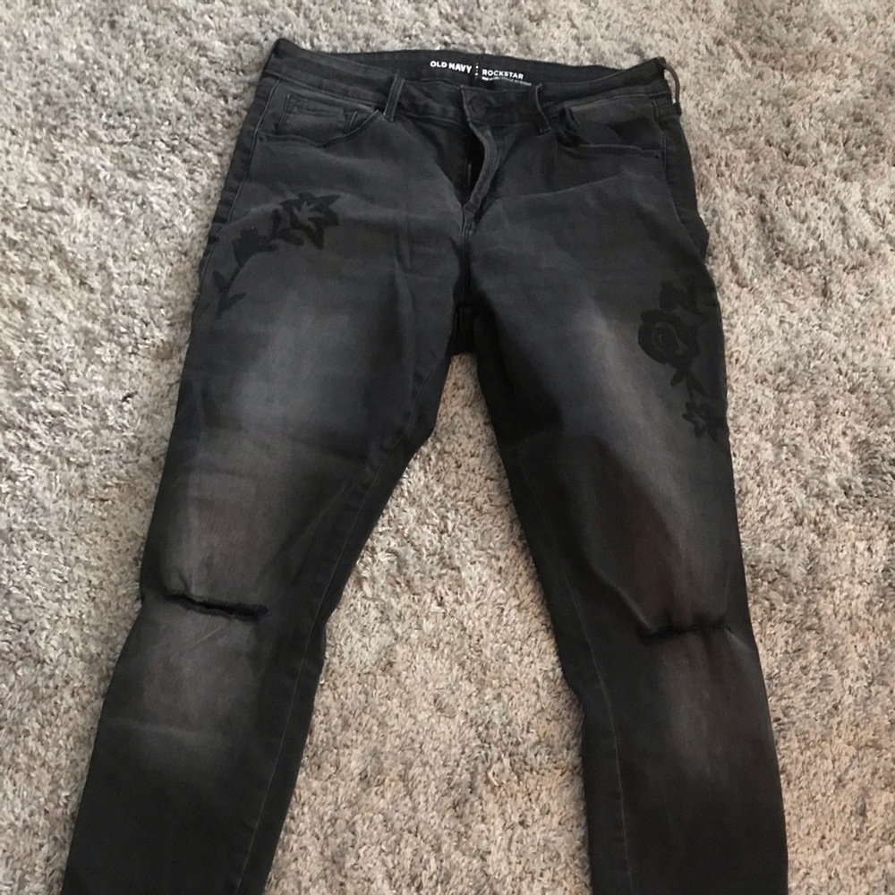Black jeans with rips and flower appliqué